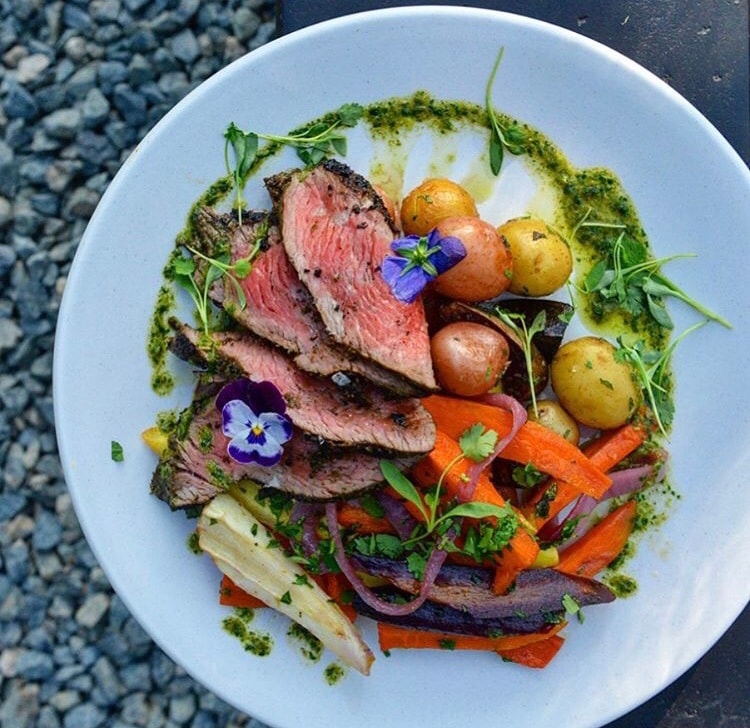 Seared steak with chimichurri roasted vegetables and edible flowers