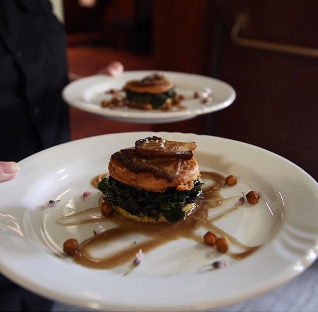 Plated polenta stack with mushrooms greens and crispy chickpeas