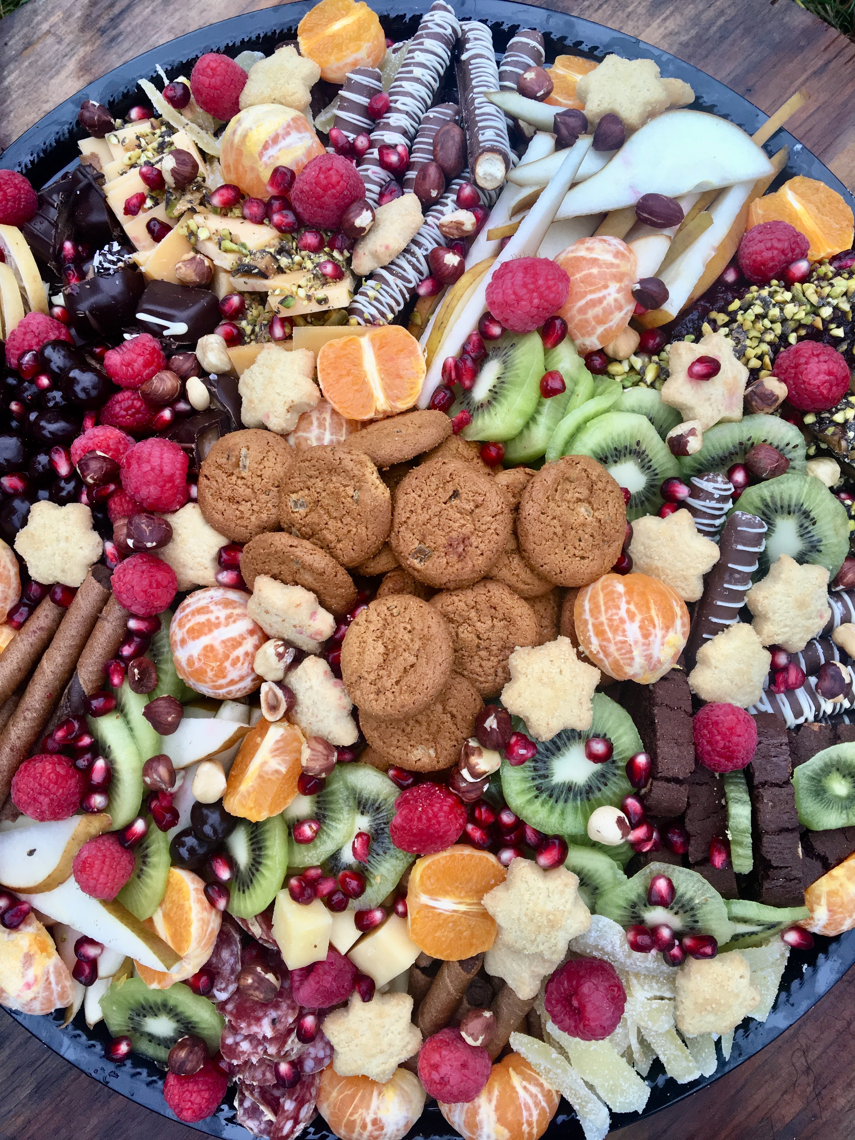 Dessert and fruit grazing board with cookies chocolates and citrus