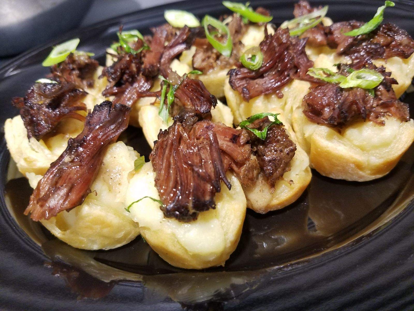 Braised short rib bites in pastry cups with green onion